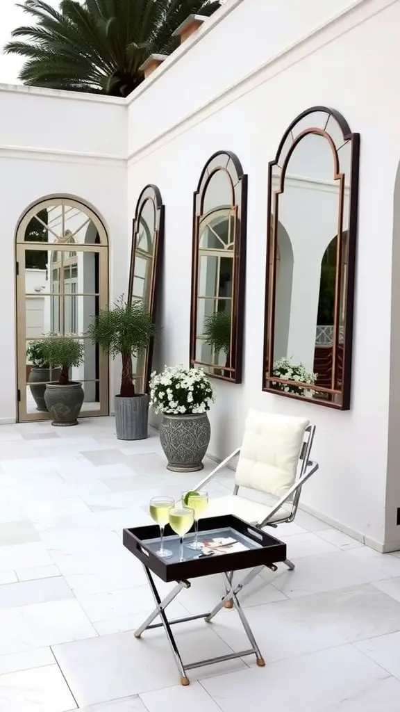 A mirror-lined terrace with two chairs and cocktails on a table, set against a scenic backdrop.