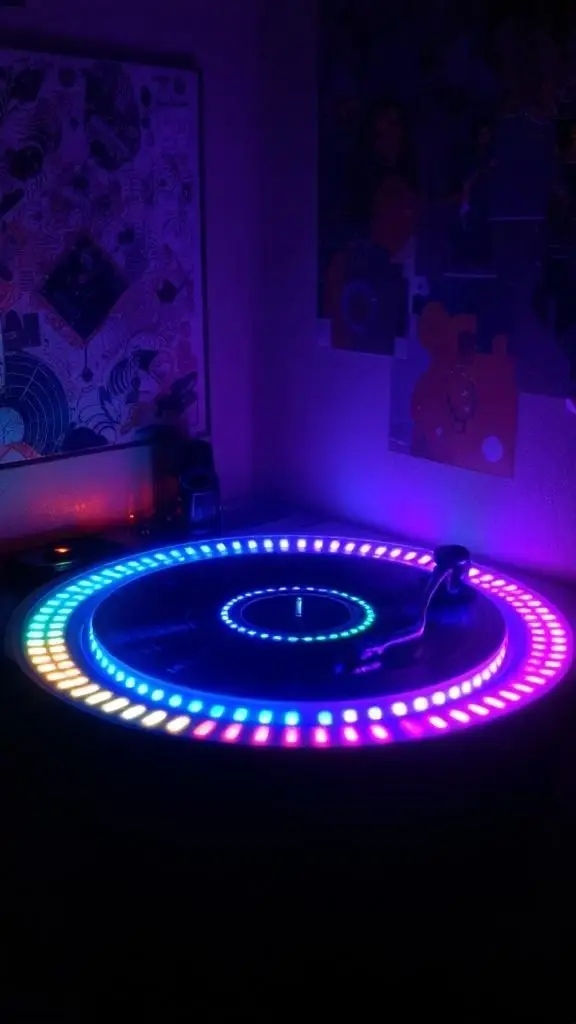 A cozy setup featuring a record player and colorful lights in a red-lit space.